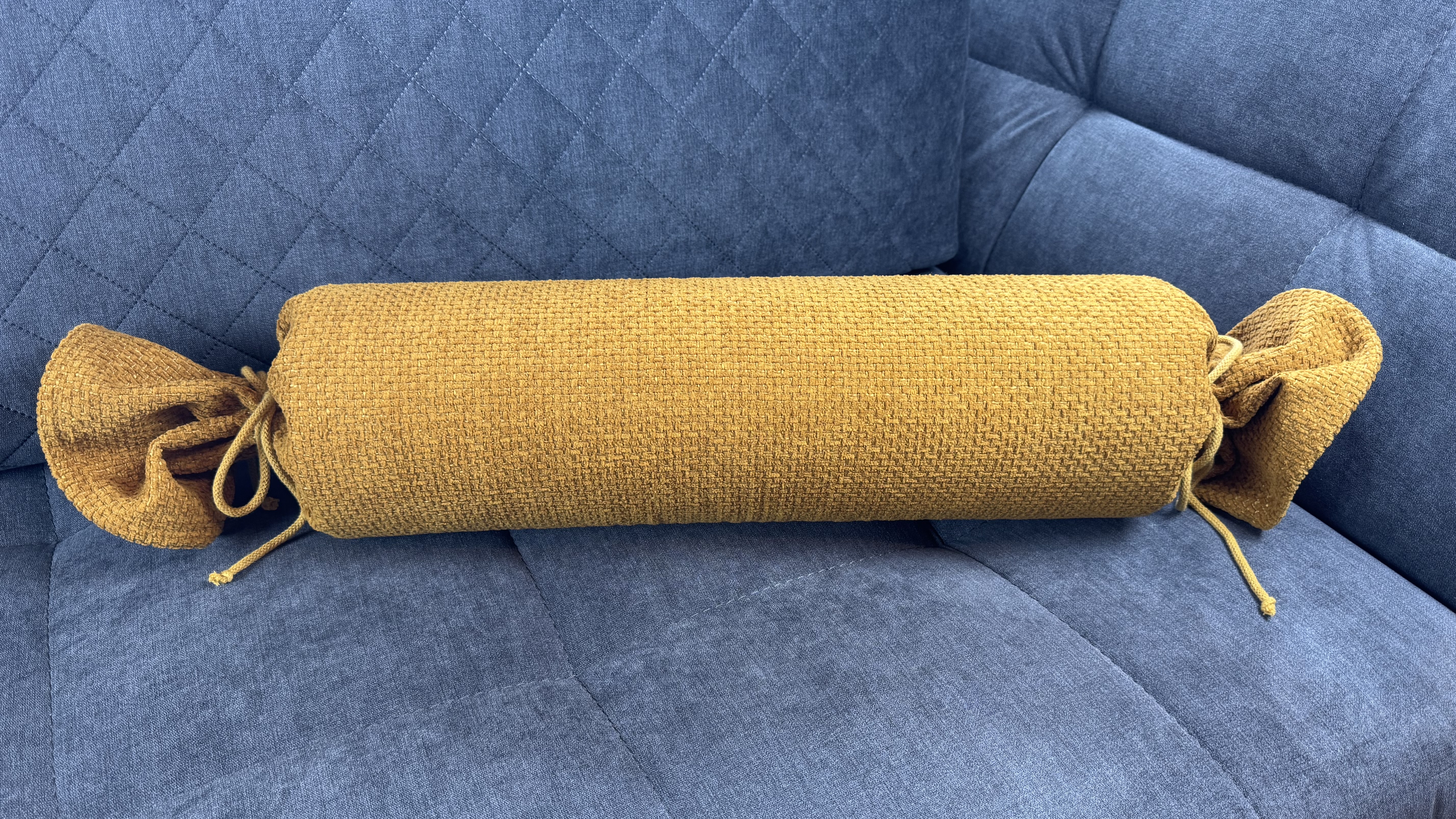 Nackenrolle Recy gelb auf Couch