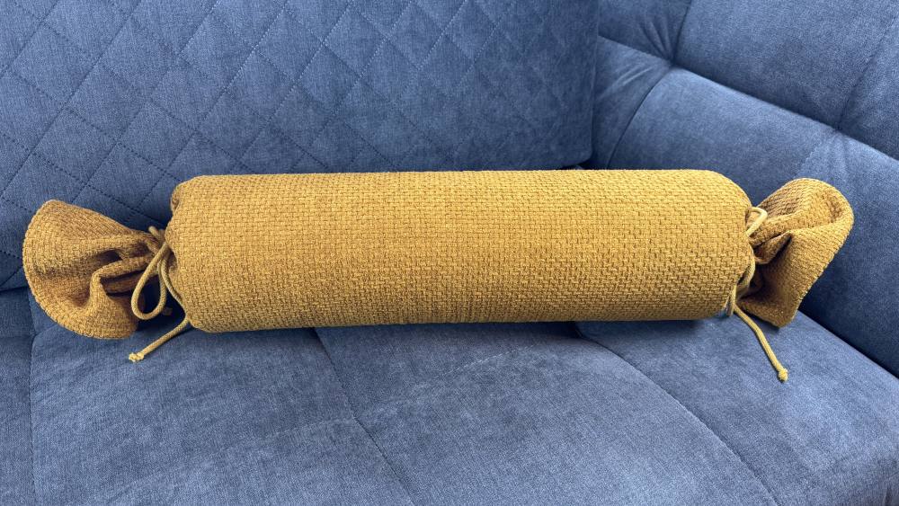 Nackenrolle Recy gelb auf Couch