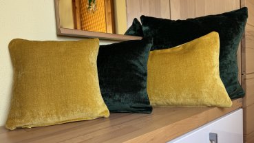 Preview: Dekokissen Chenille grün und gelb auf Bank